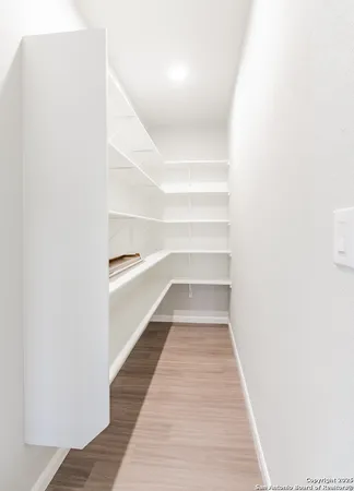 a view of a hallway with wooden floor and entryway