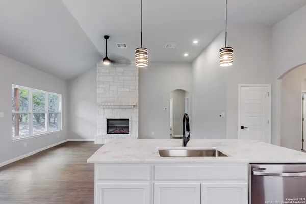a kitchen with a sink chandelier and fireplace