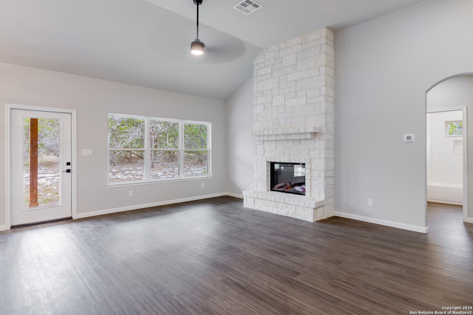 1841 Cottonwood Road Fischer, TX 78623 - Photo 22 of 45 an empty room with wooden floor fireplace and windows