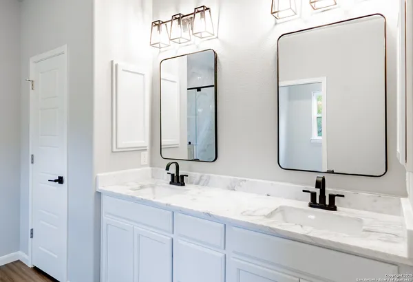a bathroom with double vanity sinks and two mirror