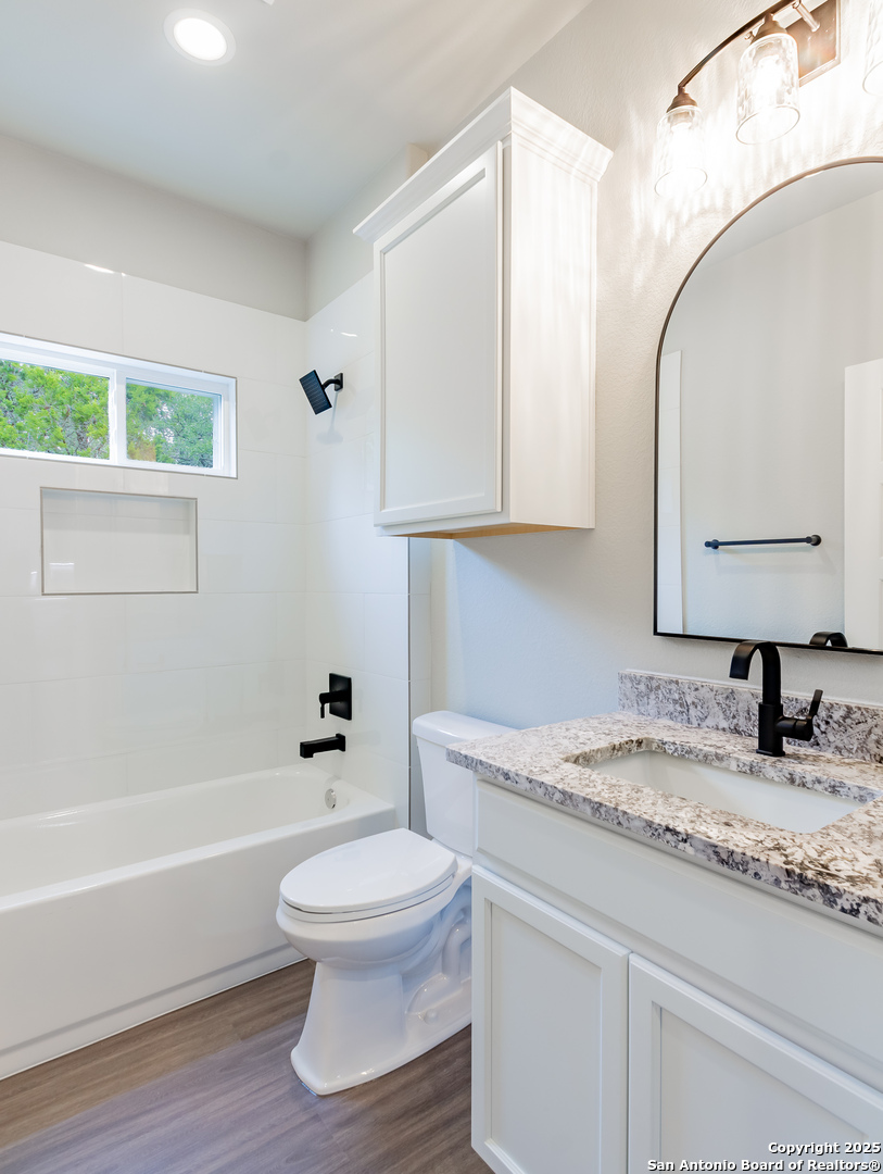 1841 Cottonwood Road Fischer, TX 78623 - Photo 33 of 45 a bathroom with a granite countertop toilet sink and mirror