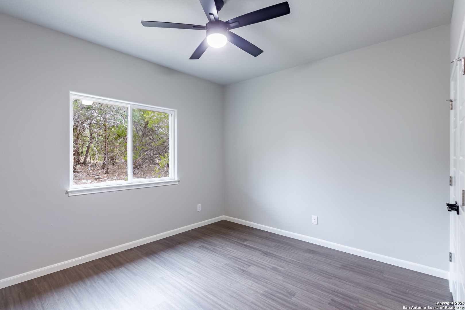 1841 Cottonwood Road Fischer, TX 78623 - Photo 34 of 45 an empty room with wooden floor fan and windows