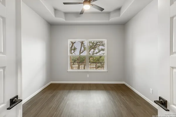 an empty room with wooden floor and windows