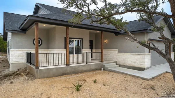 a view of a house with a wooden fence and a large tree