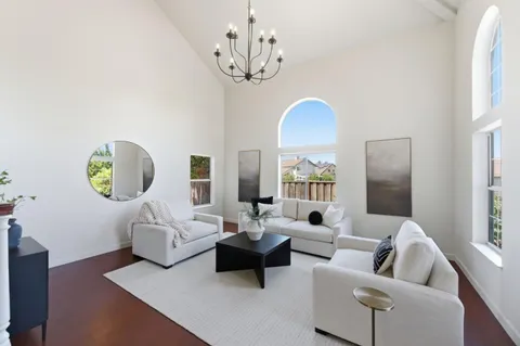 a living room with furniture a chandelier and a window