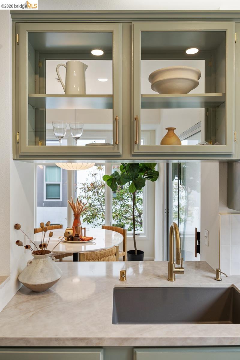 2029 Channing Way, Unit 3D Berkeley, CA 94704 - Photo 22 of 54 Kitchen featuring light green cabinetry with glass-front upper cabinets, under-cabinet lighting, and gold-tone hardware