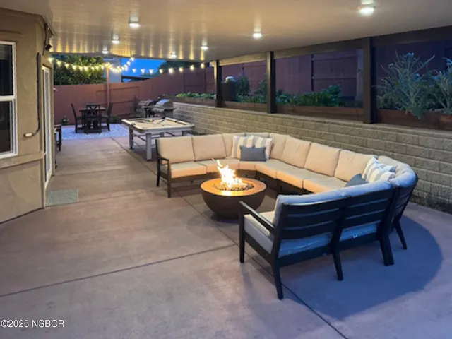 a living room with patio furniture and a potted plant
