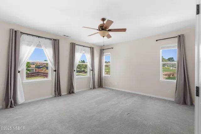 a view of a livingroom with a ceiling fan and window