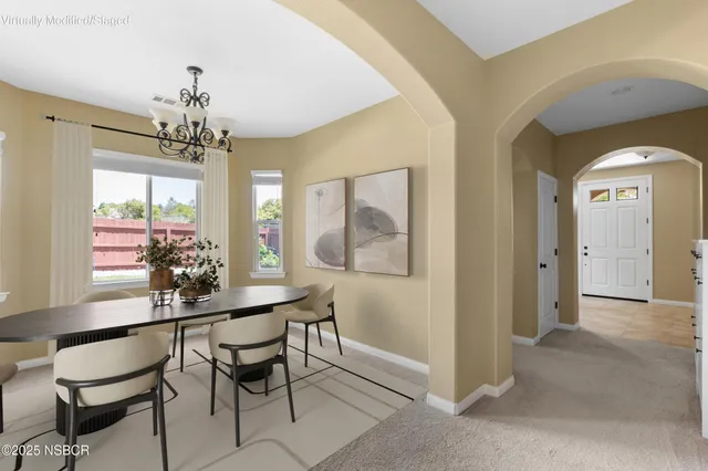 a view of a dining room with furniture and a chandelier