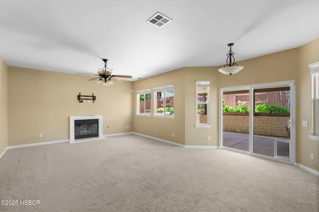 en empty room with windows and ceiling fan