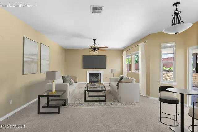 a living room with furniture a fireplace and a chandelier