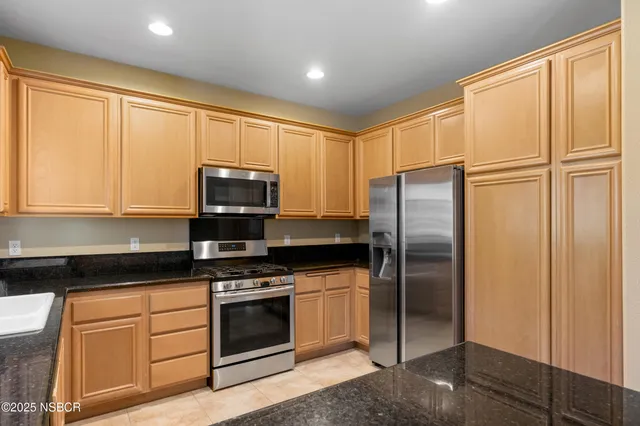 a kitchen with granite countertop a refrigerator stove and microwave