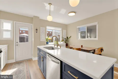 a view of a kitchen island a sink and dishwasher with wooden floor