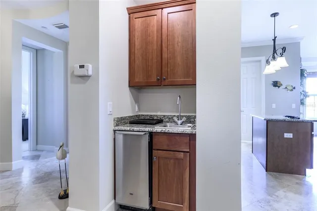 a kitchen with stainless steel appliances granite countertop a sink a stove and a wooden cabinets