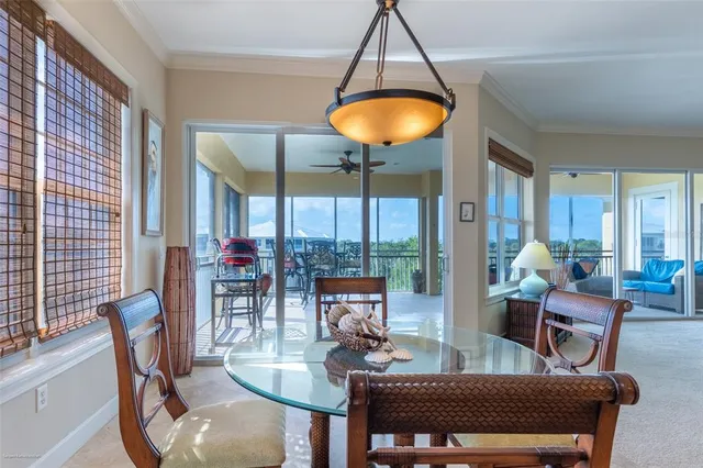 a living room with furniture kitchen view and a chandelier