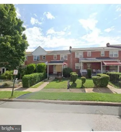 a view of a brick house next to a yard