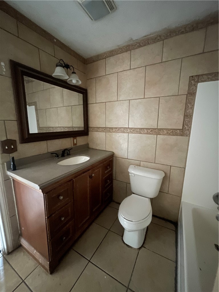 215 West 4th Street Alice, TX 78332 - Photo 14 of 14 a bathroom with a toilet sink and mirror