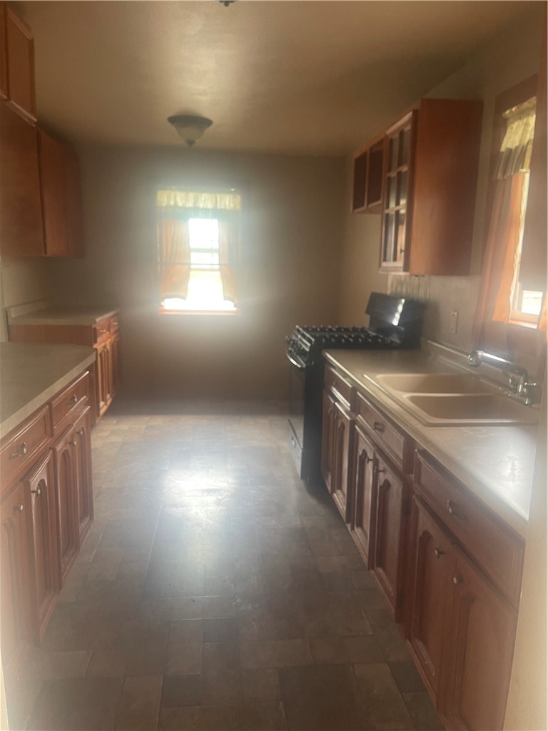 215 West 4th Street Alice, TX 78332 - Photo 5 of 14 a kitchen that has a sink a stove and a window