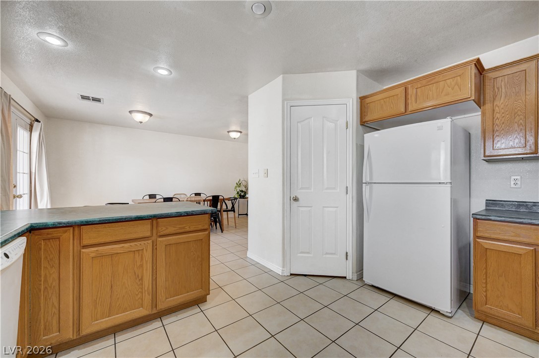 1272 Liston Avenue Logandale, NV 89021 - Photo 22 of 61 A well-lit kitchen with tiled floors transitions seamlessly into an open dining area.