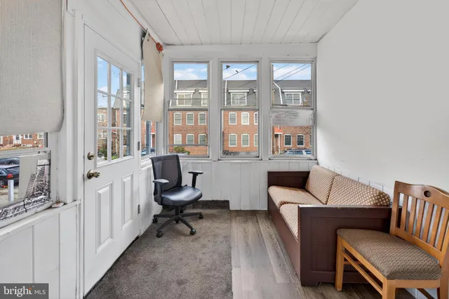 a view of a workspace with furniture and a window