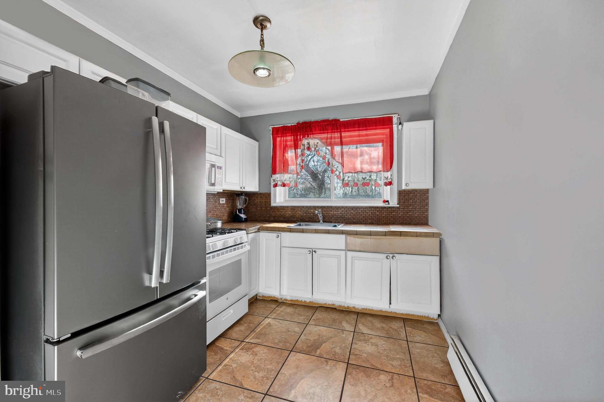 1330 South Merrimac Road Camden, NJ 08104 - Photo 7 of 17 a kitchen with stainless steel appliances a refrigerator and a stove