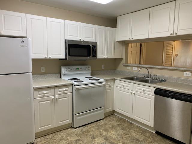 929 Morreene Road, Unit C21 Durham, NC 27705 - Photo 2 of 7 a kitchen with white cabinets sink and stainless steel appliances