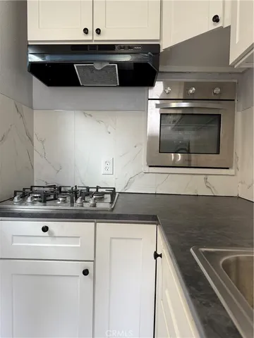 a stove top oven sitting inside of a kitchen