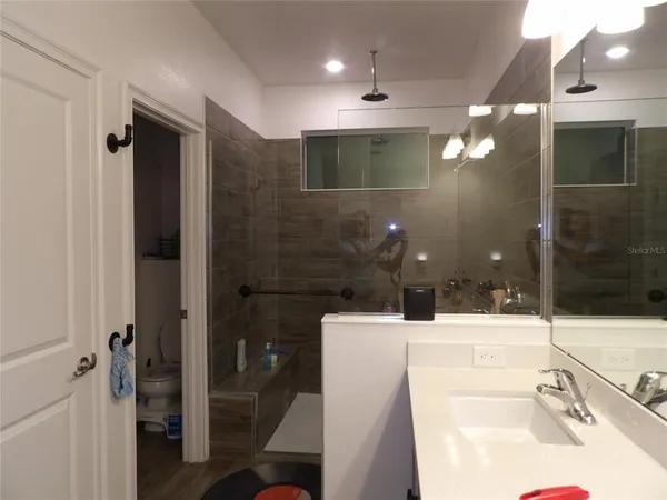 a bathroom with a sink shower and a mirror