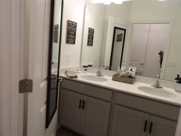 a bathroom with a double vanity sink and a mirror