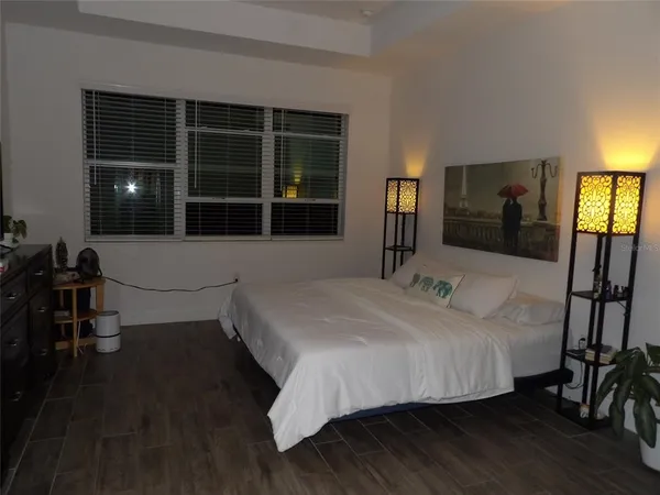 a bedroom with a bed and wooden floor
