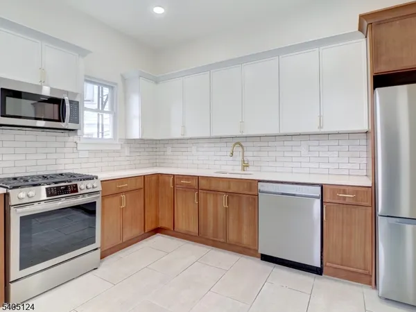 a kitchen with stainless steel appliances granite countertop a sink stove and microwave
