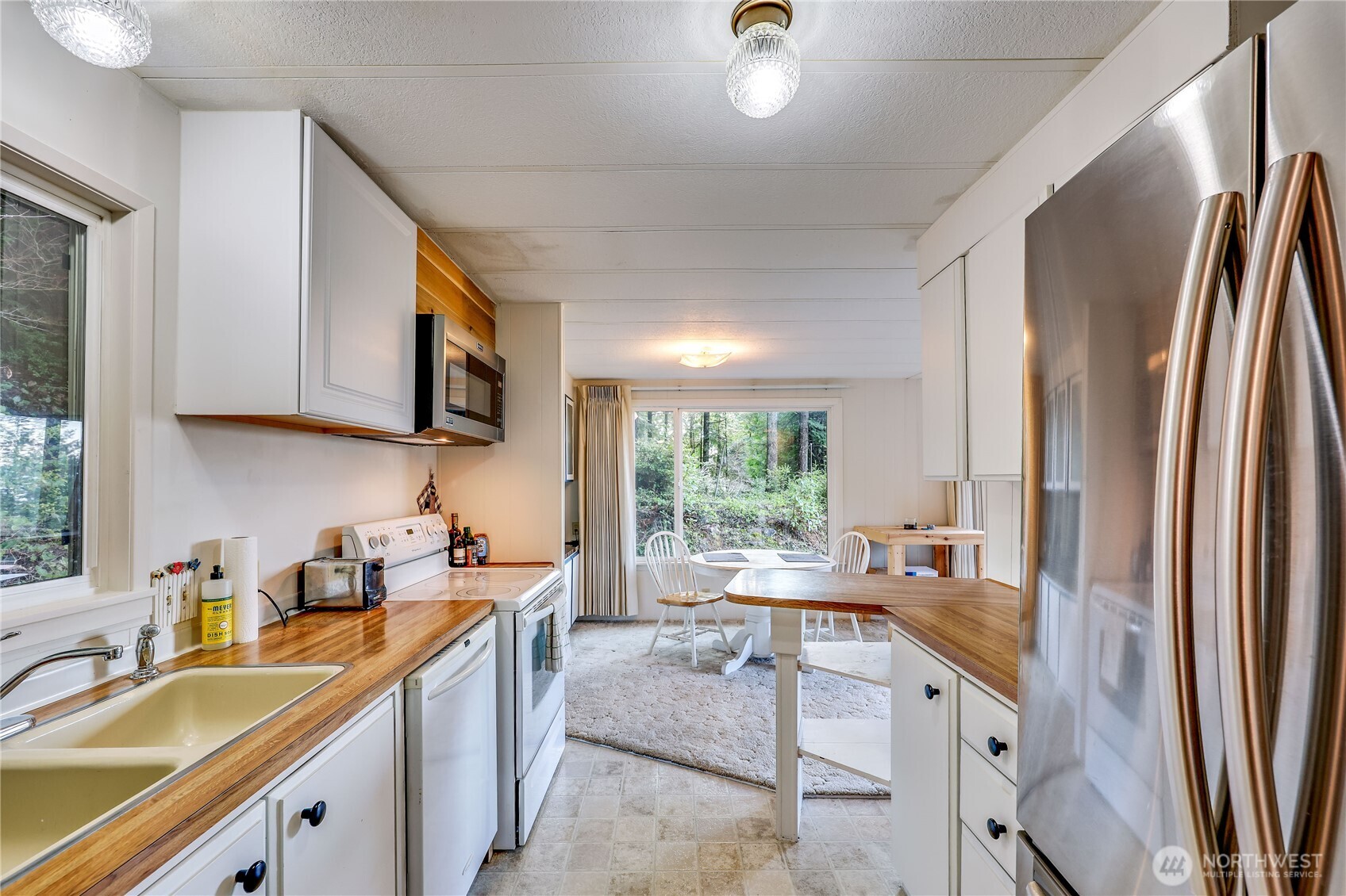 170 Cirque Drive Brinnon, WA 98320 - Photo 13 of 24 a kitchen with stainless steel appliances granite countertop a sink stove and refrigerator