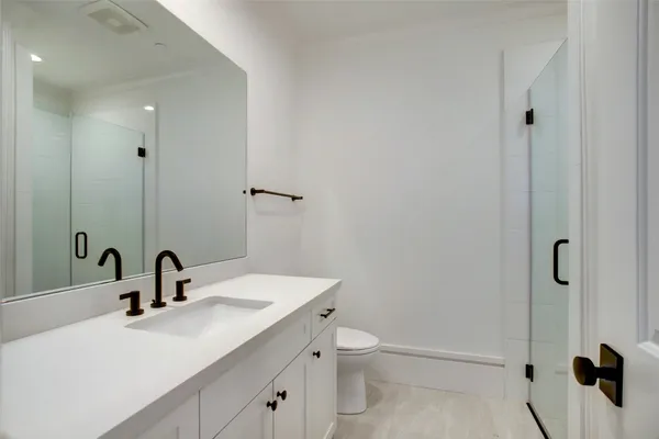 a bathroom with a toilet sink a mirror and shower