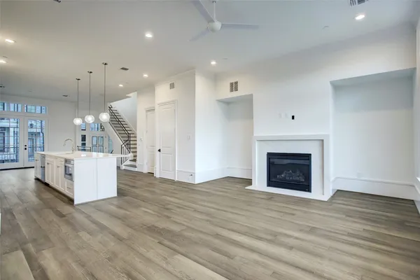 a view of kitchen and hall with wooden floor and a fireplace