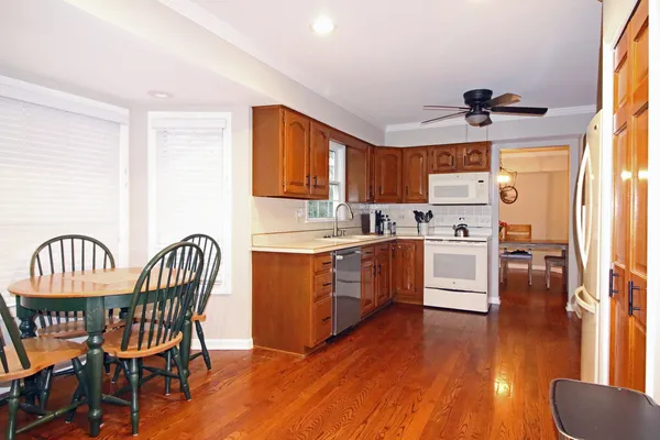 a kitchen with granite countertop a table chairs a sink dishwasher window and cabinets