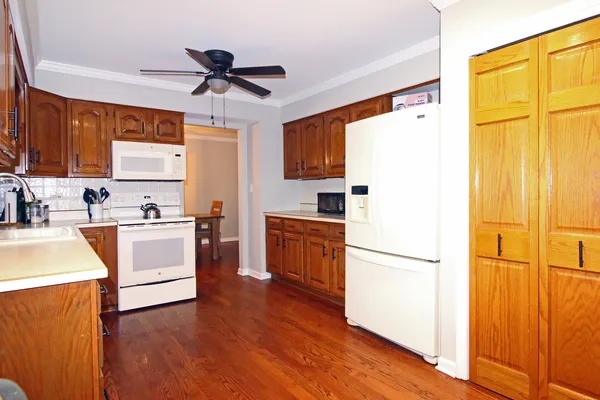 a kitchen with a refrigerator cabinets and a wooden floor