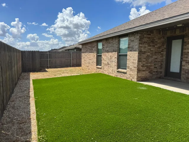a backyard of a house with table and chairs