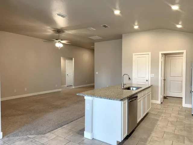 a kitchen with kitchen island granite countertop a sink and a stove top oven with granite countertops
