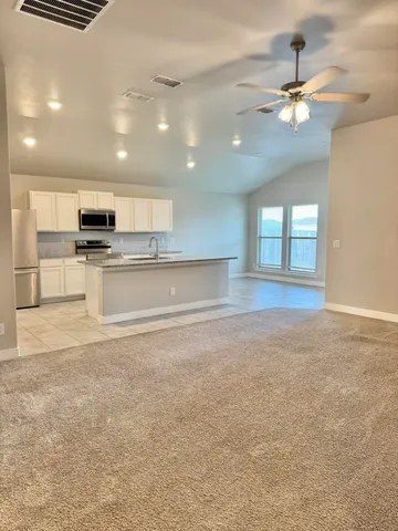 a open kitchen with kitchen island a sink stainless steel appliances and cabinets
