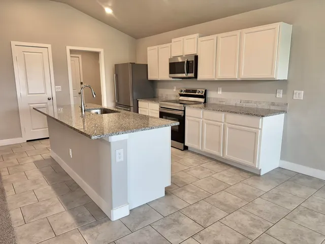 a kitchen with stainless steel appliances granite countertop a sink and a stove