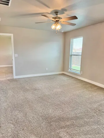 en empty room with windows and fan