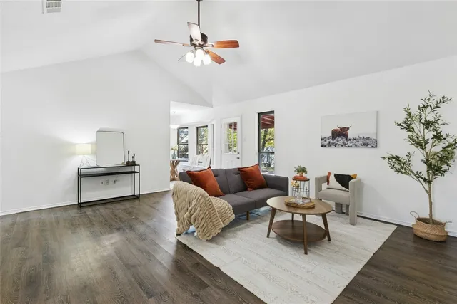 a living room with furniture and a wooden floor