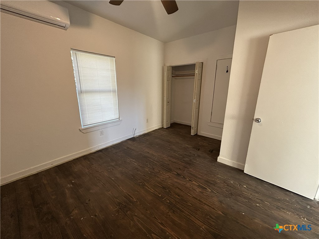 1017 West Nueces Street Victoria, TX 77901 - Photo 15 of 31 an empty room with wooden floor and windows