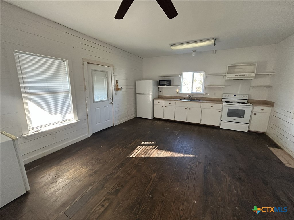 1017 West Nueces Street Victoria, TX 77901 - Photo 30 of 31 a kitchen with a stove cabinets and a wooden floor