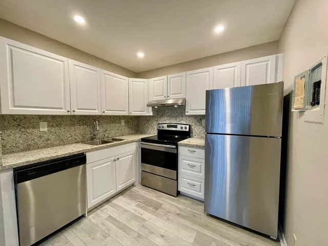 a kitchen with a refrigerator sink and cabinets