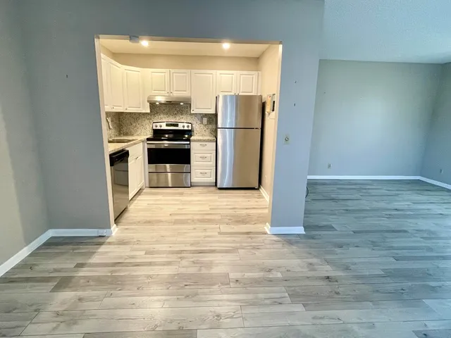 a kitchen with granite countertop a refrigerator and a stove
