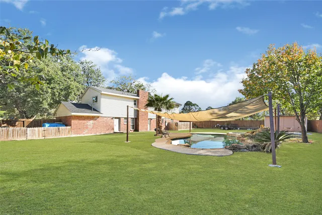 a white house with a big yard and large trees