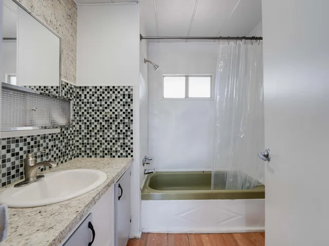 a bathroom with a sink a toilet a shower and bathtub