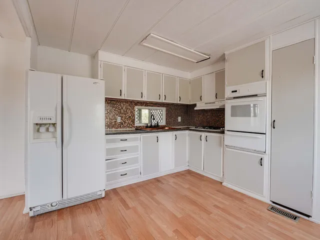a kitchen with white cabinets and white appliances