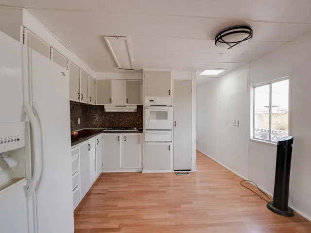 a kitchen with stainless steel appliances granite countertop a refrigerator and a stove top oven